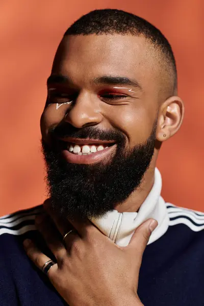 Beau jeune homme vêtu d'une tenue tendance, respirant confiance et joie dans un cadre lumineux. — Photo de stock