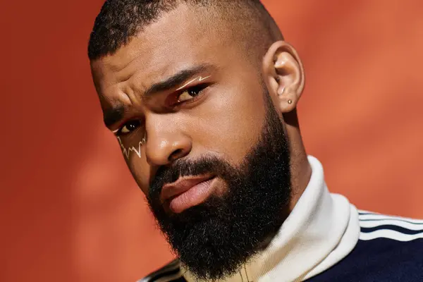 Stylish man with a groomed beard poses confidently against a vibrant backdrop. — Stock Photo