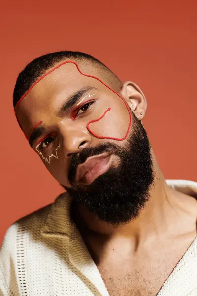 Handsome man with a well groomed beard and unique facial art exudes confidence in a trendy outfit. — Stock Photo