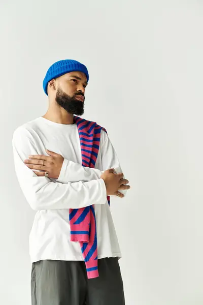 Un giovane elegante in un maglione colorato colpisce una posa premurosa. — Foto stock