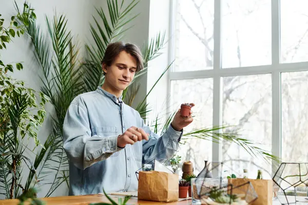 A young artist nurtures plants while embracing creativity in a lively art studio. — Stock Photo