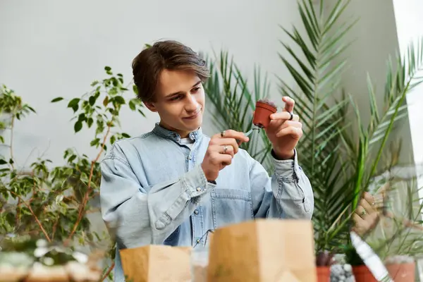A young artist interacts with a small plant pot amid lush greenery and art supplies. — Stock Photo