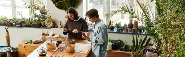 Young couple create art in a bright studio filled with plants and materials. — Stock Photo