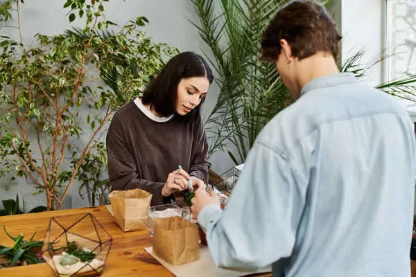 Young couple create a project in a plant filled studio, showcasing their imagination. — Stock Photo