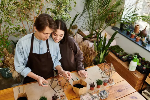 A young couple creates unique decor items from plants in a vibrant art studio. — Stock Photo
