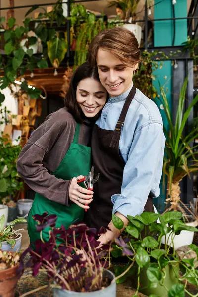 Loving couple work joyfully in an art studio, nurturing plants and showcasing their creativity. — Stock Photo