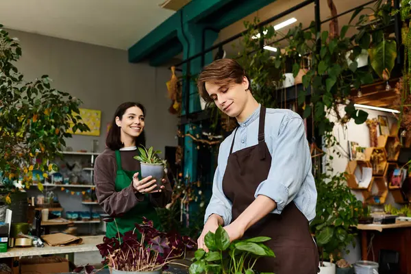 Young couple showcase their artistic talents in a lively space filled with plants. — Stock Photo