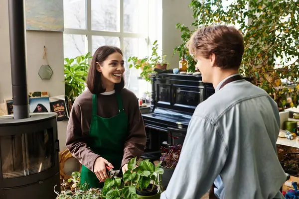 Loving couple share a moment in a lively art studio, exchanging ideas and joy amidst greenery. — Stock Photo