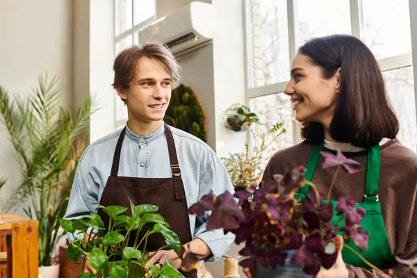 Creative couple engage in lively conversation while surrounded by plants and artistic materials. — Stock Photo
