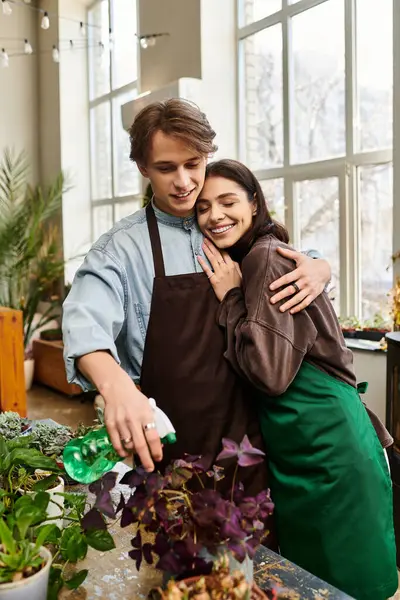 Couple shares love and creativity in a bright art studio, surrounded by vibrant plants. — Stock Photo