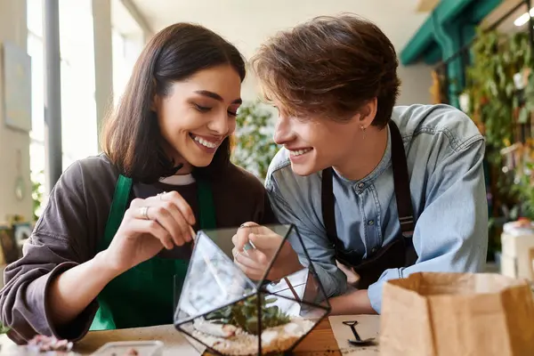 Loving couple work together in an art studio, sharing smiles as they craft a unique terrarium. — Stock Photo