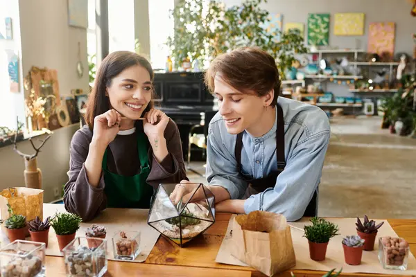 Young couple joyfully create a terrarium in a vibrant, inspiring studio. — Stock Photo