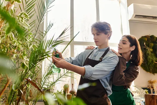 Creative couple collaborate in a lively studio, exchanging ideas while tending to plants and artwork. — Stock Photo
