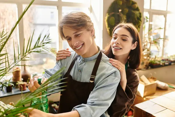 Young couple joyfully nurture plants and share inspiration in an art studio. — Stock Photo