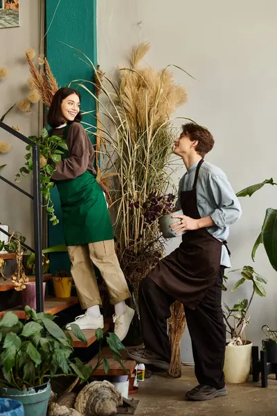 Creative couple share joyful moments in a colorful studio, surrounded by plants and unique decor. — Stock Photo