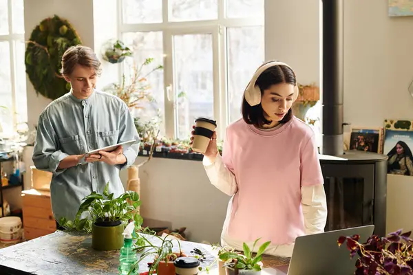 Creative couple collaborate in a lively studio, surrounded by greenery and crafting unique projects. — Stock Photo