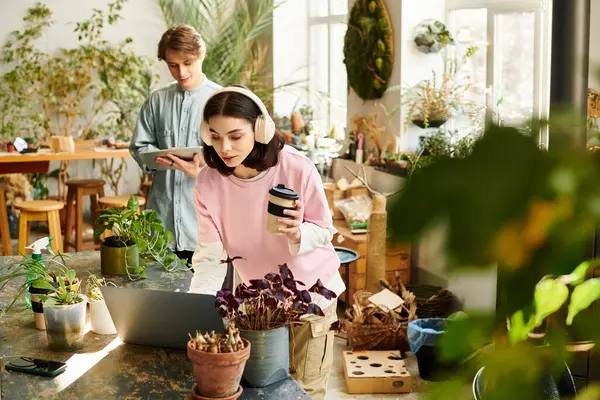 Two creatives engage in art activities in a thriving, plant filled studio. — Stock Photo