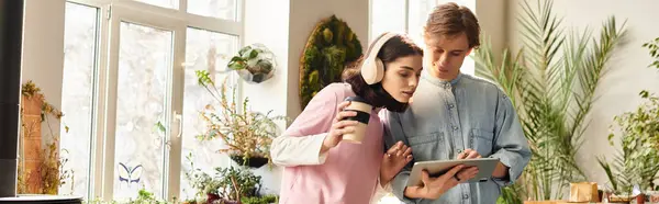 Creative couple discuss as they explore digital art on a tablet in their bright studio. — Stock Photo