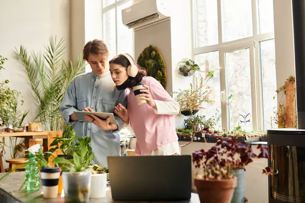 Loving couple engage in a collaborative moment, surrounded by art supplies and greenery. — Stock Photo