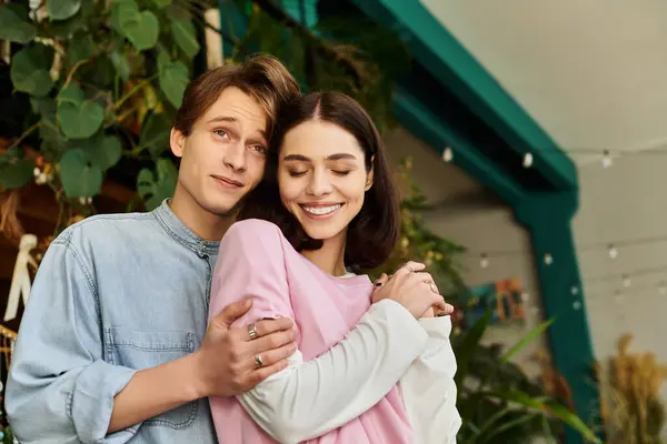 Loving couple share a warm moment in an inspiring art studio filled with greenery and creativity. — Stock Photo