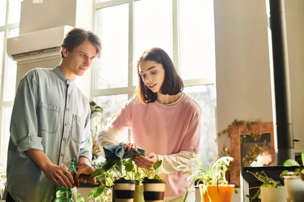 Casal criativo se envolver em cuidados com as plantas, cercado por criatividade e luz natural em seu estúdio de arte. — Fotografia de Stock