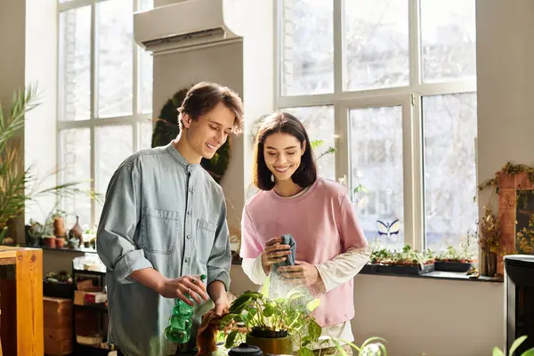 Loving couple joyfully care for vibrant plants in a bright and inspiring art studio. — Stock Photo