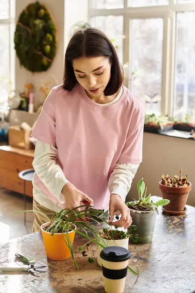 An artist engages with plants while nurturing creativity in a vibrant art studio environment — Stock Photo