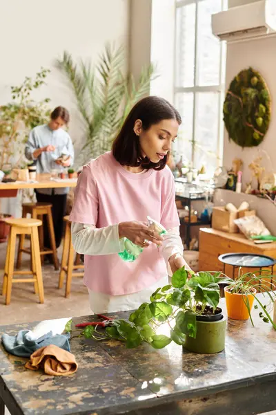 En un refugio artístico, uno tiende a las plantas, mientras que otro explora la imaginación y la artesanía. - foto de stock