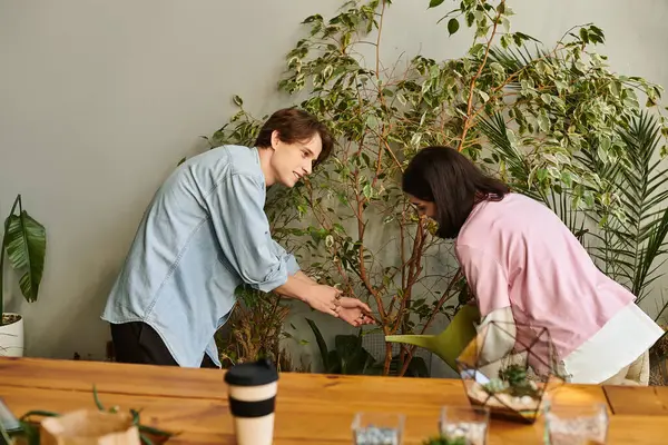 Creative couple collaborate, nurturing plants and sharing creative ideas in a lively studio. — Stock Photo