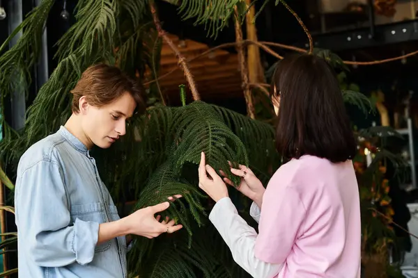 Coppia creativa impegnarsi in una vivace discussione, osservando verde lussureggiante nel loro spazio di lavoro creativo. — Stock Photo
