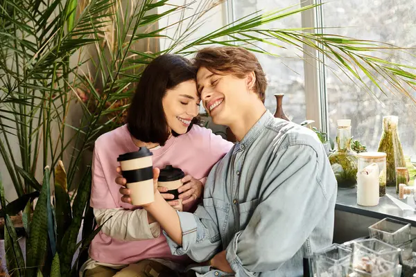 Two friends sip warm coffee in a creative art studio brimming with plants and joy. — Stock Photo