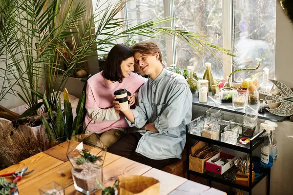 Young couple enjoy each others company in a vibrant art studio filled with plants and tools. — Stock Photo
