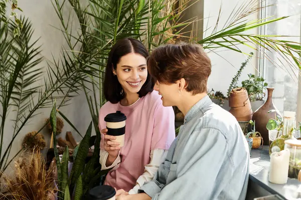 Loving couple joyfully engage in conversation while enjoying beverages in a vibrant art studio. — Stock Photo