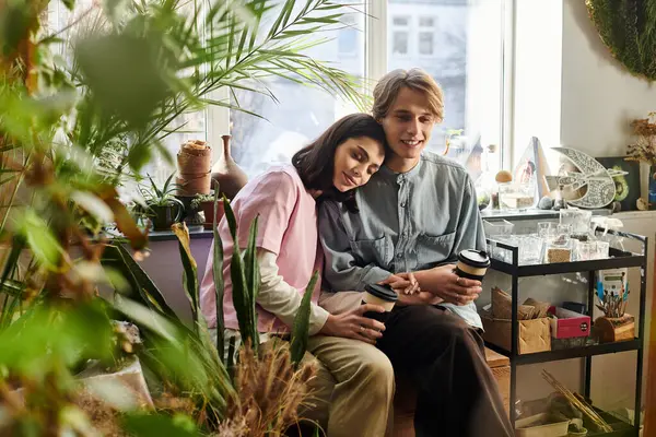 Couple shares joyful moments in a vibrant art studio brimming with greenery and creativity. — Stock Photo