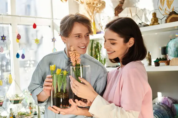 Loving couple happily share their floral arrangements, displaying creativity in the studio. — Stock Photo