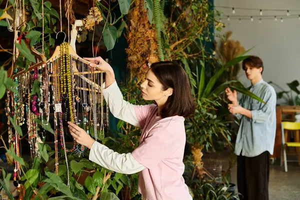 Creative couple engage in a creative process surrounded by lush plants and colorful art materials. — Stock Photo