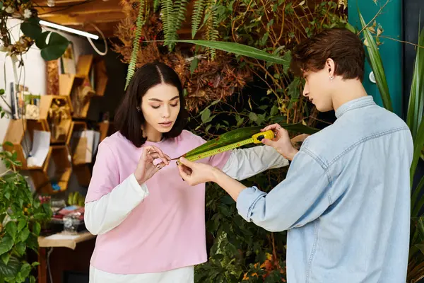 Young couple measure materials in a vibrant, green art studio filled with inspiration. — Stock Photo