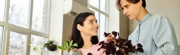 Dos jóvenes artistas se involucran con las plantas, compartiendo ideas creativas e inspiración en un estudio brillante. - foto de stock