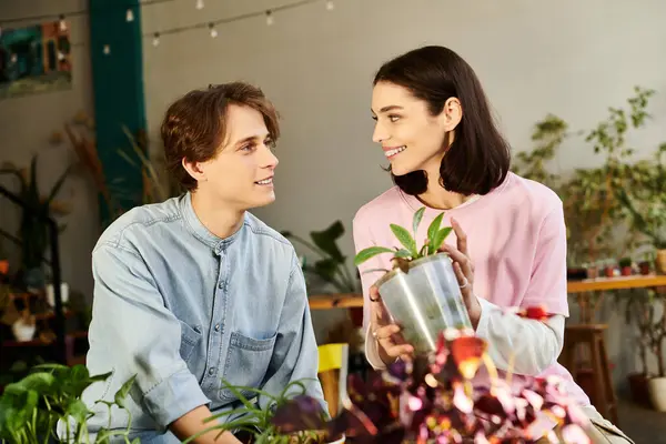 Young couple enjoy a joyful moment in an art studio filled with plants and creativity. — Stock Photo