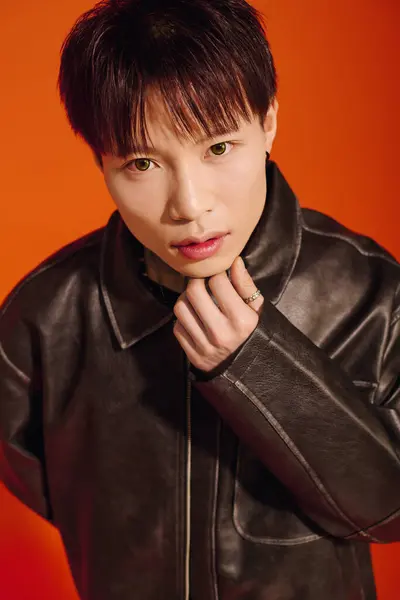 Ein junger Mann in leuchtend orangefarbenem Outfit zeigt sein stylisches Outfit und bezaubernden Blick. — Stockfoto