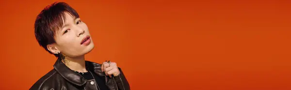 Handsome young man displays his unique style and confidence against a bold orange backdrop. — Stock Photo