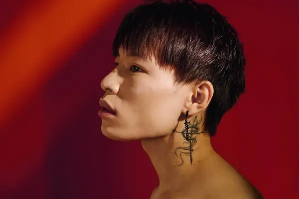 A handsome young man displays his stylish earring, highlighted by vivid colors. — Stock Photo