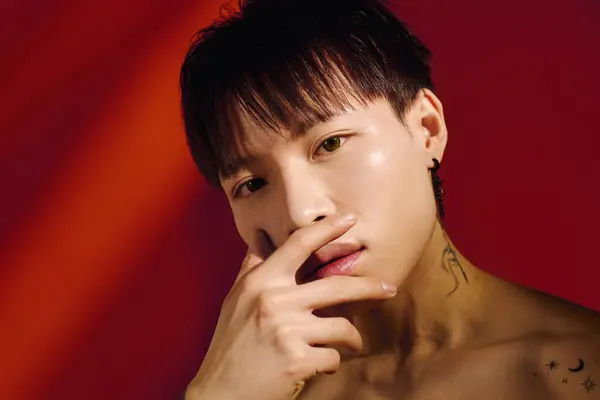 A confident young asian man shows off his unique style and charm in a vibrant setting. — Stock Photo