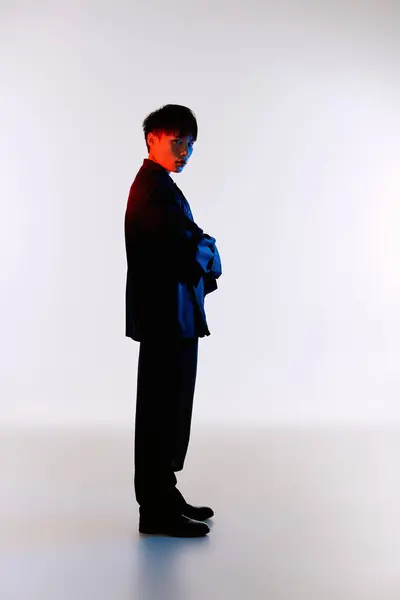 Un hombre asiático guapo en un traje elegante se levanta con confianza, mostrando un aspecto moderno y elegante. — Stock Photo