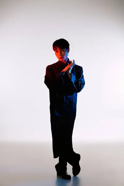 A handsome Asian man showcases his unique style while striking a pose in a sleek outfit. — Stock Photo