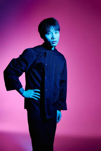 A young and handsome asian man stands confidently in a stylish outfit, showcasing a striking pose. — Stock Photo