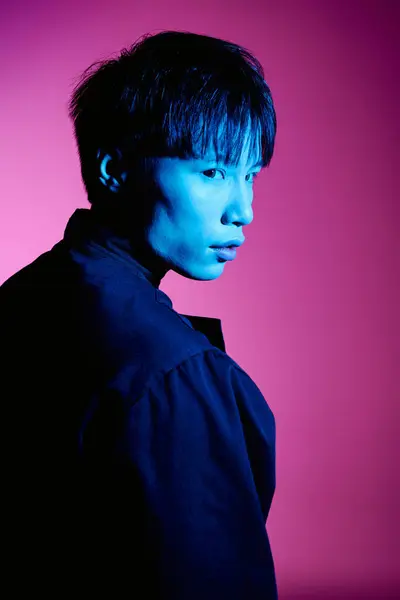 A stylish young Asian man stands out with his charm in a vibrant, colorful setting. — Stock Photo