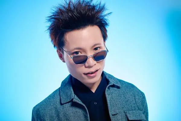 Confident young man flaunts trendy sunglasses and jacket, radiating charm. — Stock Photo