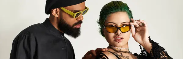 A trendy couple poses confidently, flaunting stylish sunglasses and diverse outfits, banner — Stock Photo