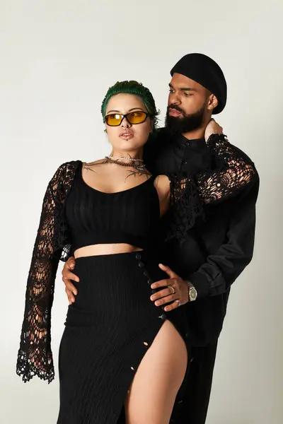 Um jovem casal em trajes elegantes posa juntos em um estúdio, irradiando confiança e charme. — Fotografia de Stock